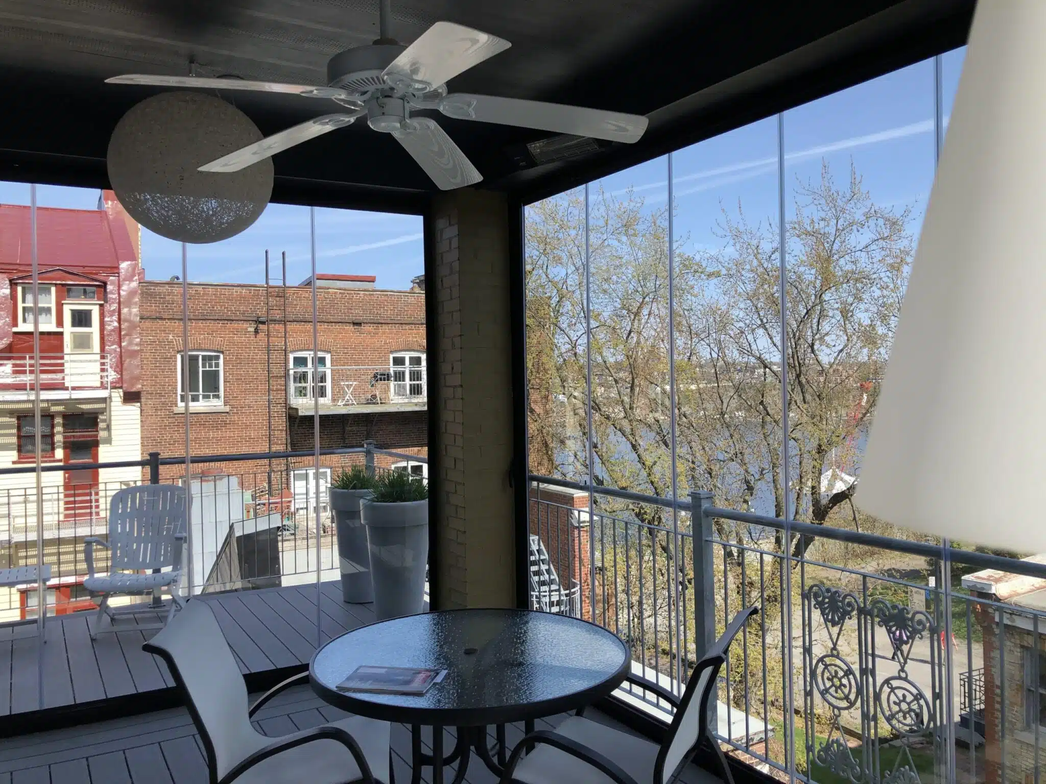 Covered balcony with round table and glass enclosure