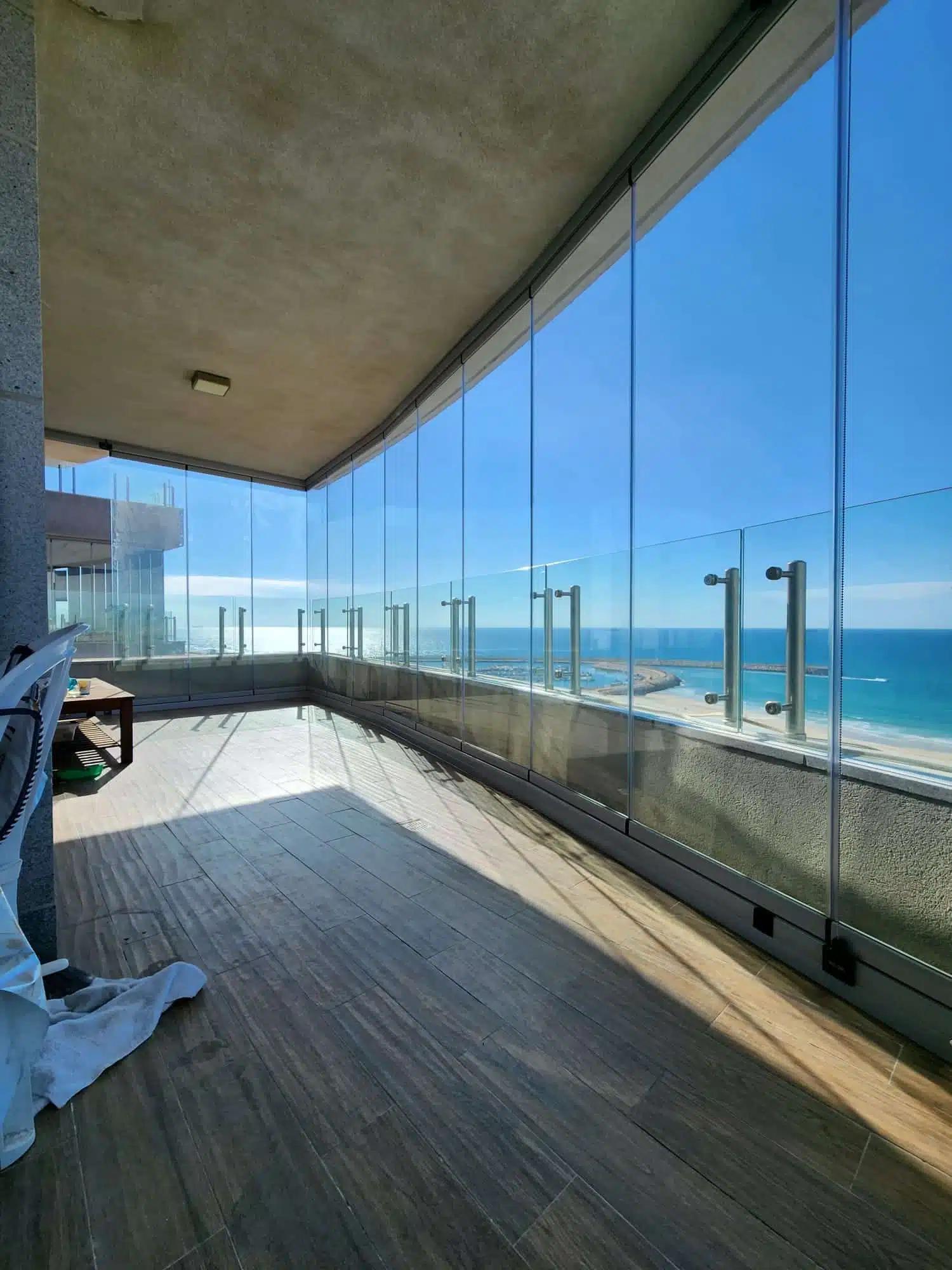 Covered balcony with frameless sliding glass system